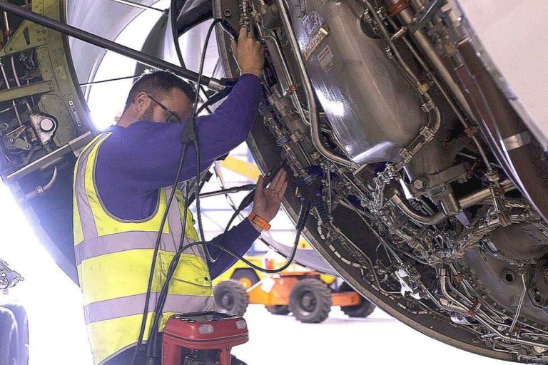 Red ExLRT tool is being used to test an aircraft engine by an MRO technician in an aircraft maintenance hangar.